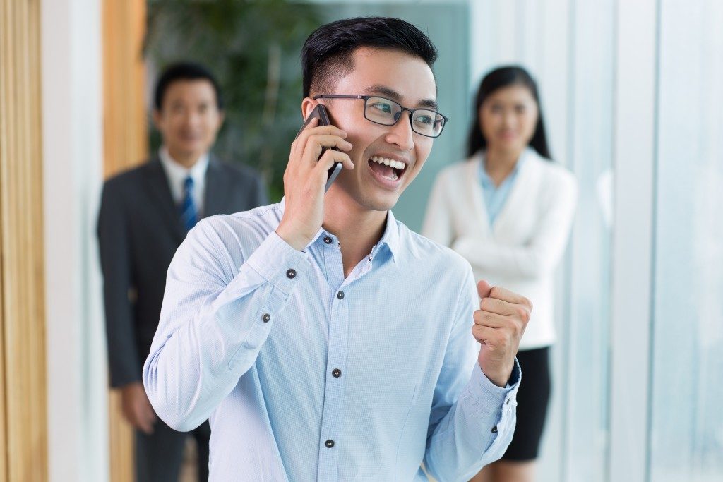 Happy businessman talking on phone and smiling
