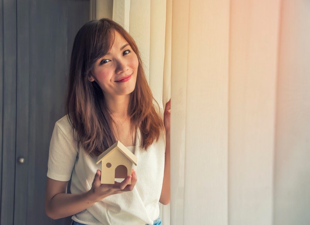 woman holding a miniature house