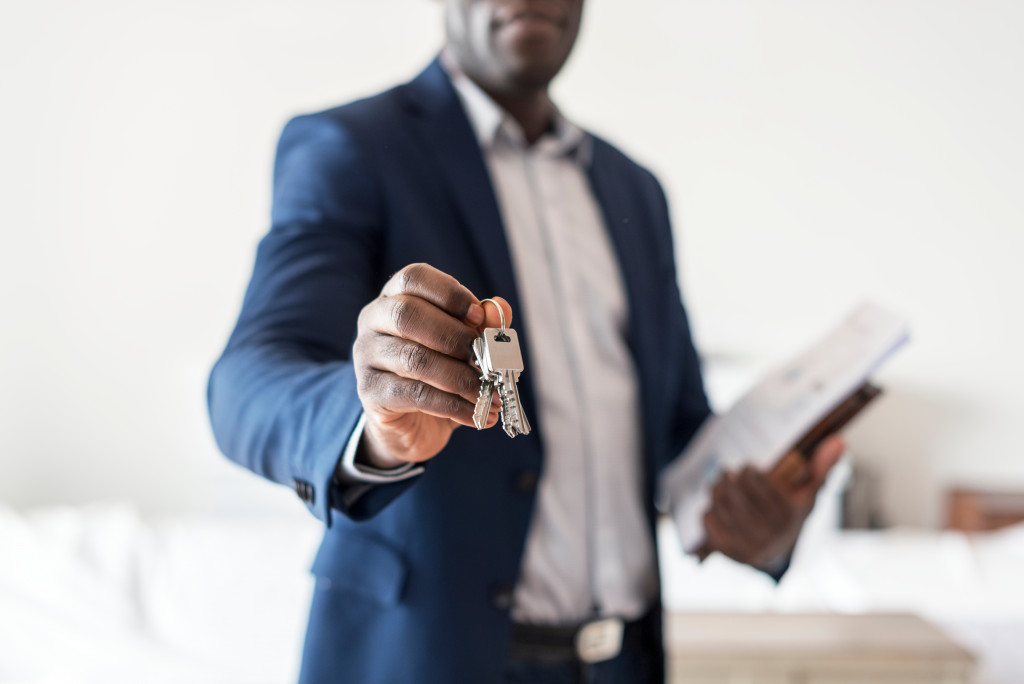 male agent handing a key to another person