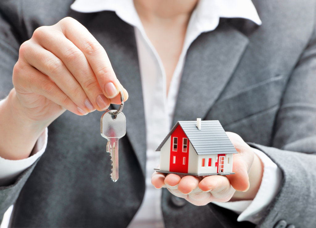 realtor with house model and key