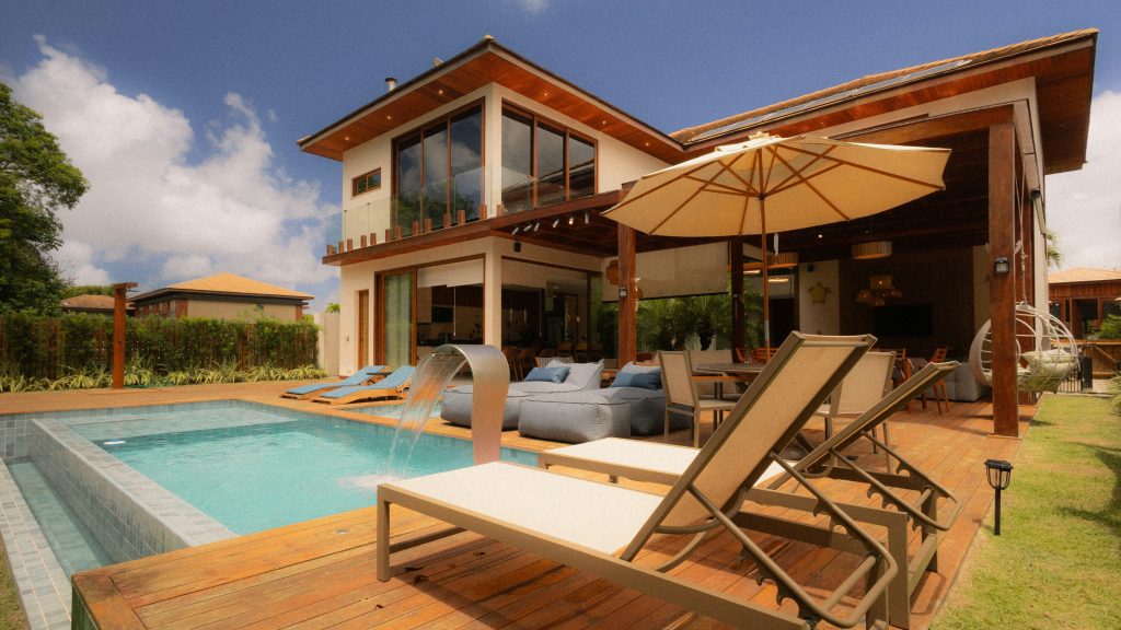 modern home featuring a pool, sunbeds, and outdoor seating