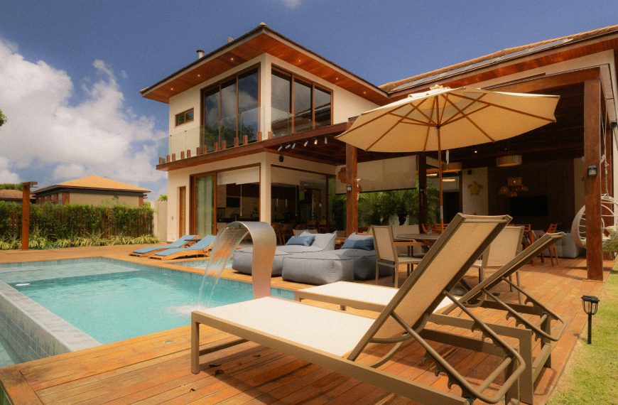 modern home featuring a pool, sunbeds, and outdoor seating